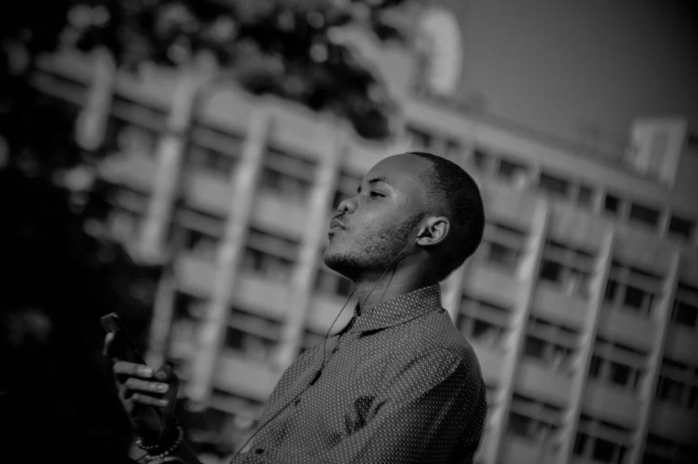Paint By Numbers | Kinshasa - Man In Checked Shirt Holding Camera In Grayscale