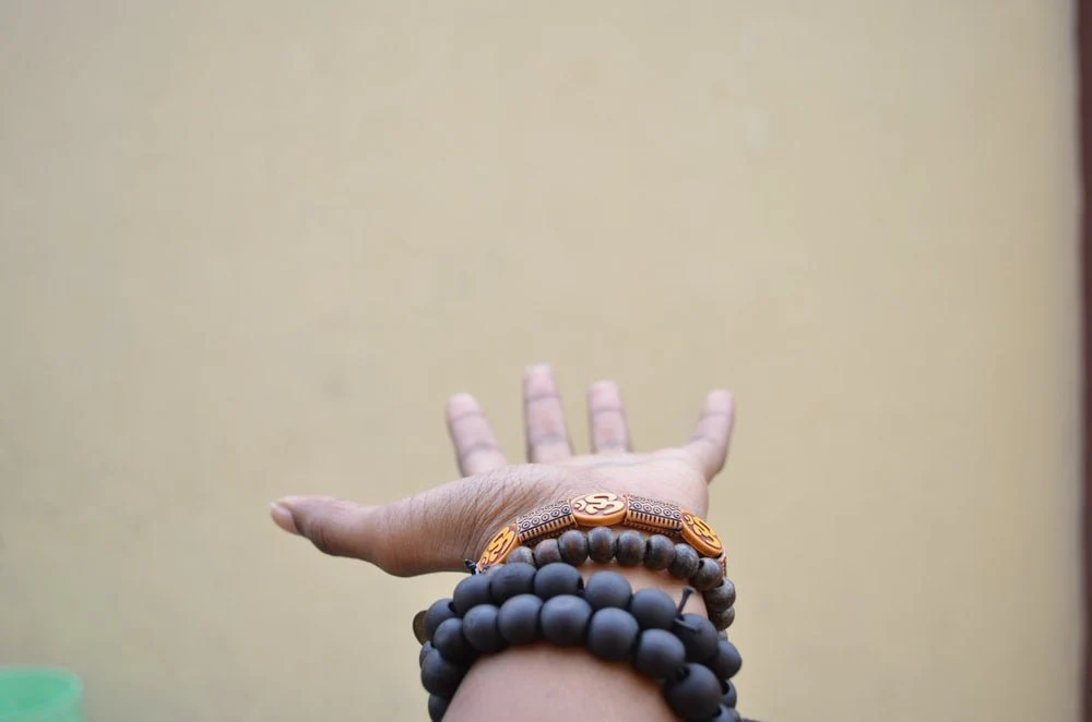 Paint By Numbers | Lagos - Person Hand With Black Beaded Bracelets